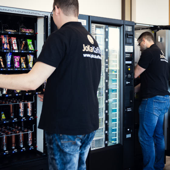 Automatenauffüller und Servicetechniker begutachten Snackautomat und Kaffee- und Heissgetränke Standgeräte